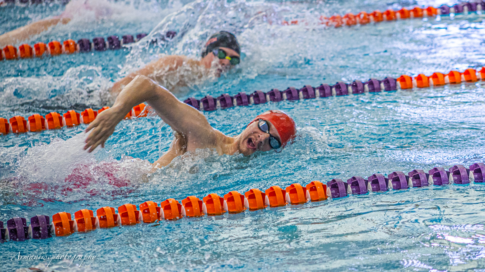 Competitive swimmer racing in a pool during a swim meet